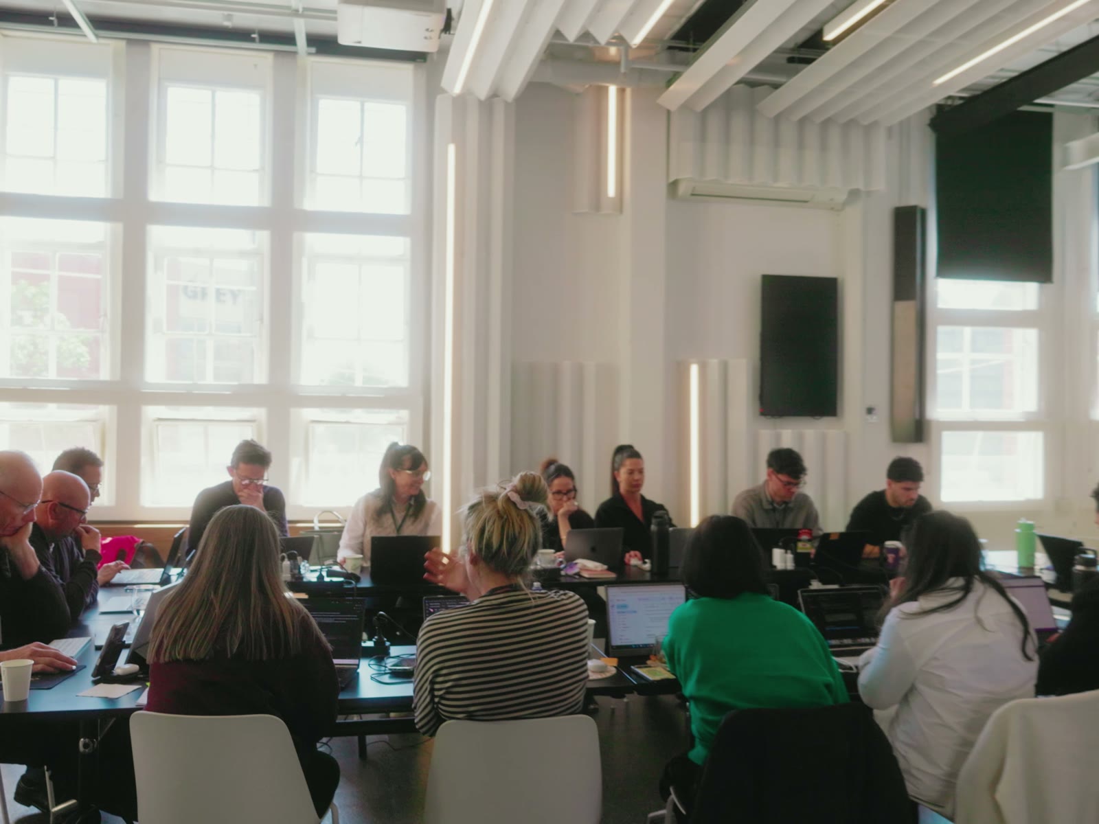 The room building on laptops, tables of attendees